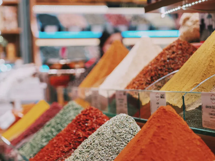 Coloured spice powders on a wooden shelf